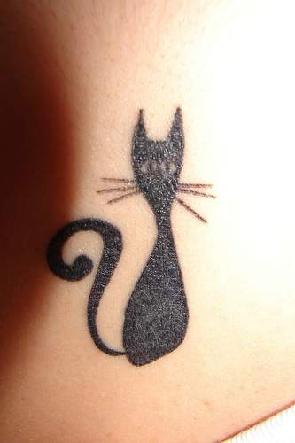 Le tatouage de chat noir étonné