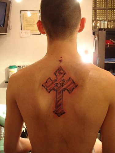 Memorial cross tattoo on back