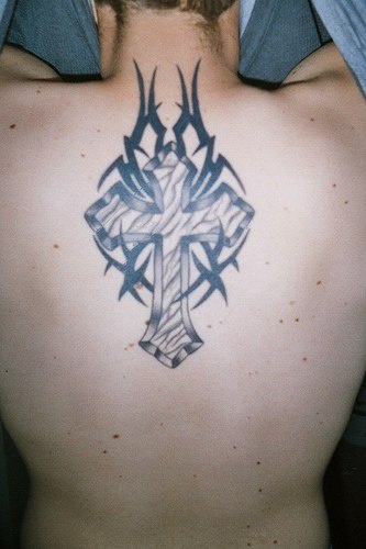 Cross with tribal tracery  tattoo
