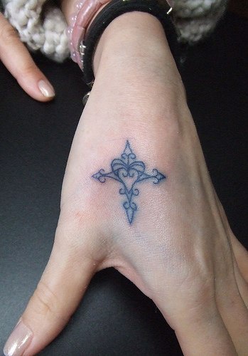 piccola croce trafori tatuaggio sulla mano