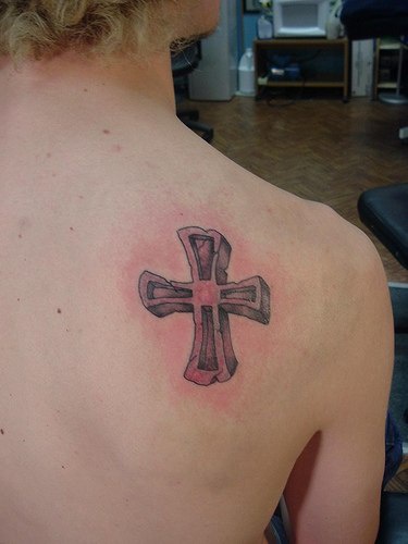 Stone cross tattoo on shoulder