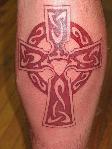tatuaje en tinta rojade cruz en estilo céltico con corazón