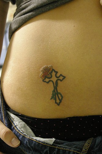 tatuaje femenino de pequeña cruz con rosa