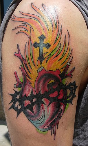 Heart in thorns and flame coloured tattoo