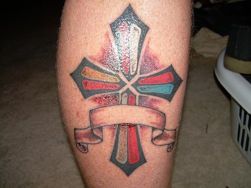 tatuaje incompleto colorido de cruz con cinta
