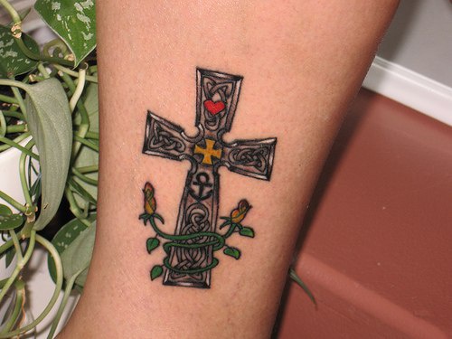 tatuaje colorido de cruz con flores