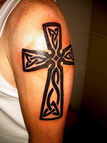 tatuaje en el brazo de cruz en estilo céltico