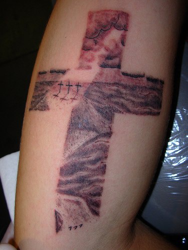 Cross with cavalry landscape in it tattoo