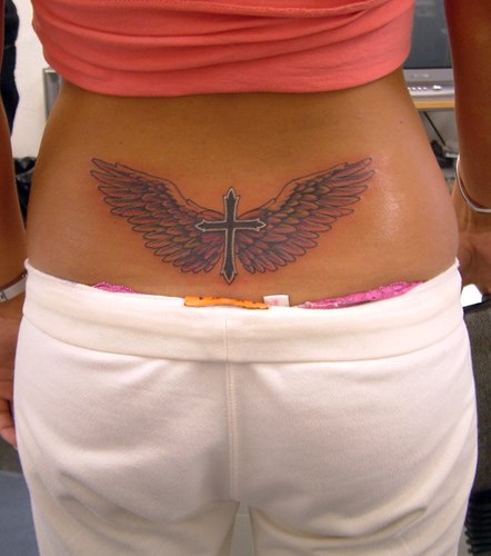 Winged cross tattoo on lower back