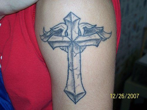 tatuaje en el brazo de cruz con alas