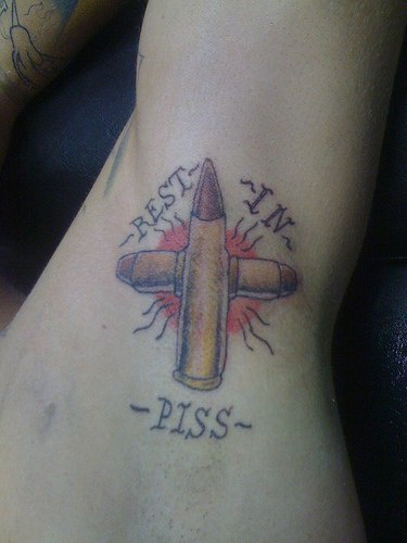 tatuaje de cruz hecha de balas de ejército