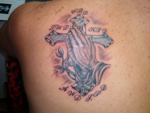 tatuaje de cruz con manos rezando