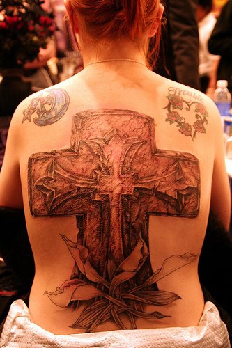 tatuaje conmemorial de enorme cruz de piedra con flores