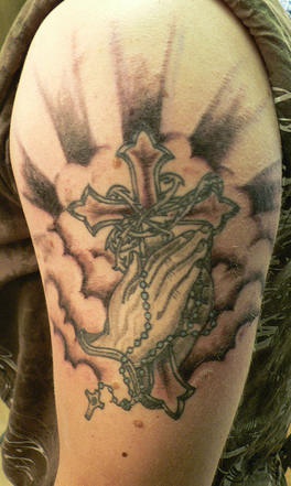 Cross with praying hands in sky tattoo