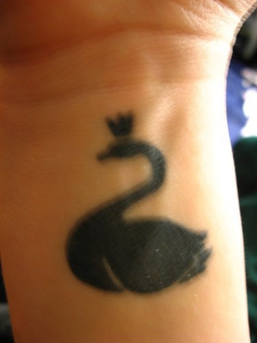Black swan in crown wrist tattoo