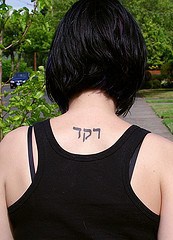 Dance in hebrew tattoo on back
