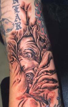 Le tatouage de démon en agonie sur le bras