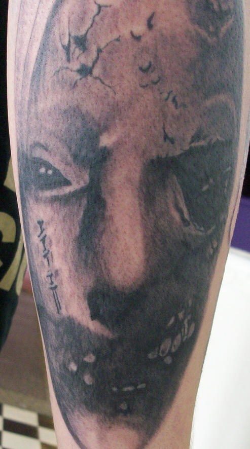 Tattoo von schwarzem, fürchterlichem Dämonkopf am Unterarm
