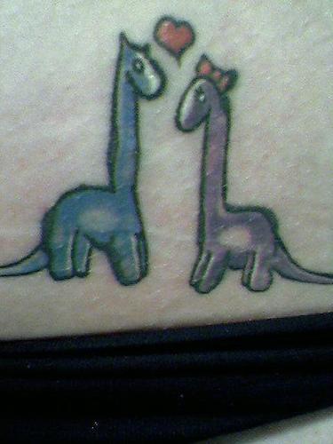 El tatuaje estilo caricatura de dos dinosaurios diplodocos enamorados con corazon
