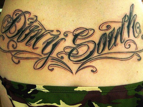 Tattoo on lower back, dirty south, styled  inscription
