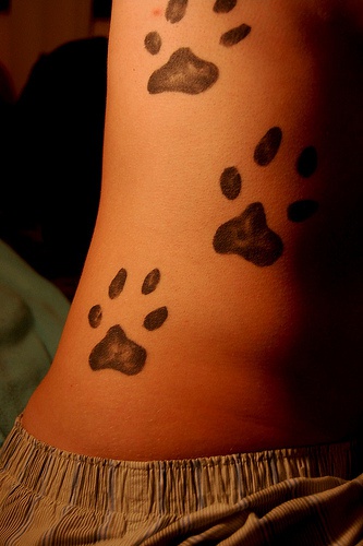 Le tatouage de trois empreinte de pattes de chien