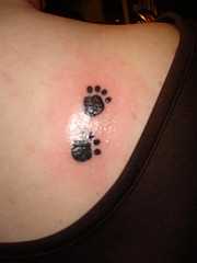 Two paw prints tattoo on back