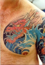 Le tatouage de dragon rouge dans le mer sur l"épaule