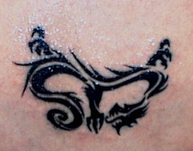 drago tribale inchiostro nero tatuaggio