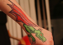Green dragon with red wings tattoo