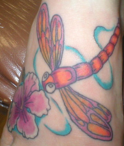 Tatuaje a color de libélula y una flor