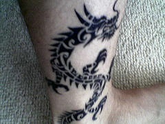Black ink tribal dragon tattoo