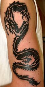 Tatuaje negro en mano de un dragón