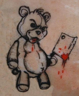 Evil teddy bear with hand ax tattoo