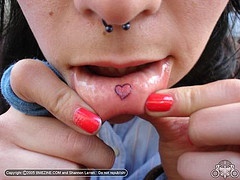 simbolo cuore sul interno di labra tatuaggio