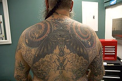 tatuaggio a tema occulto con le ali e spirali