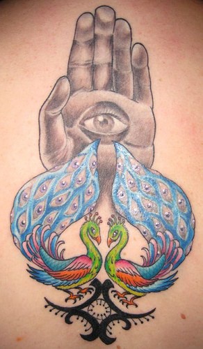 Le tatouage d’œil sur le bras avec des paons