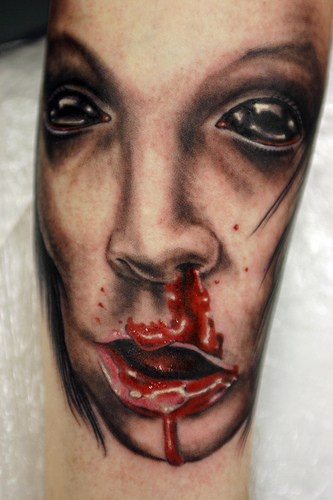 Woman face with black eyes tattoo