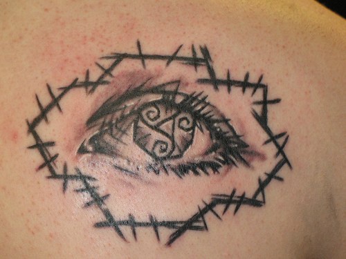 Tatuaje de ojo con tracería de palos