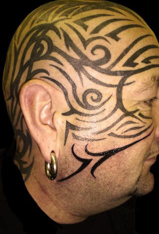 Tatuaje tribal de grandes dimensiones en cara y cabeza