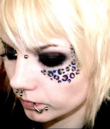Tatuaggio piccolo segno di leopardo sul viso della ragazza