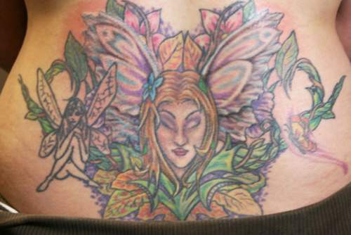 Un gros tatouage coloré de fée en fleurs