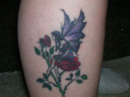Le tatouage de fée sur la rose rouge sur la jambe