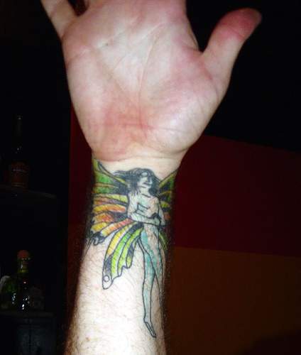 Colourful fairy tattoo on wrist