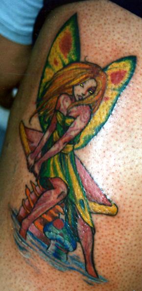 Colourful fairy on mushroom tattoo