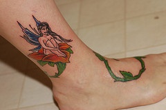 Small fairy on thorned rose on leg