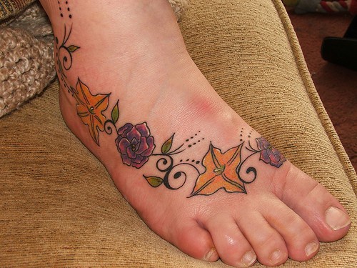 Tatuaje en el pie, una fila de flores multicolores