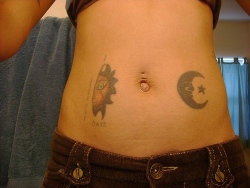 Female stomach tattoodays, moon and sun, decorated