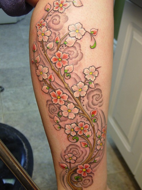 Le tatouage de belle branche de petites fleurs sur le mollet