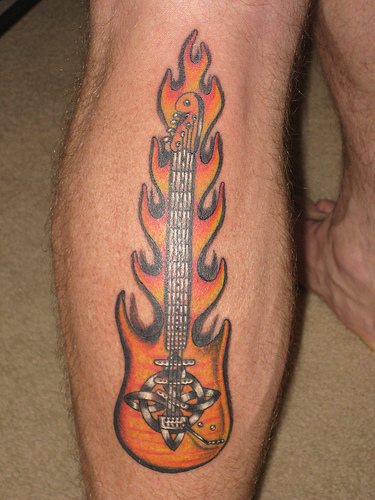 Guitar on fire coloured tattoo