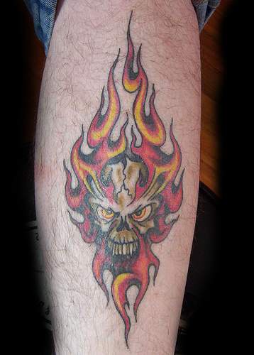 Tatuaje a color de calavera en fuego